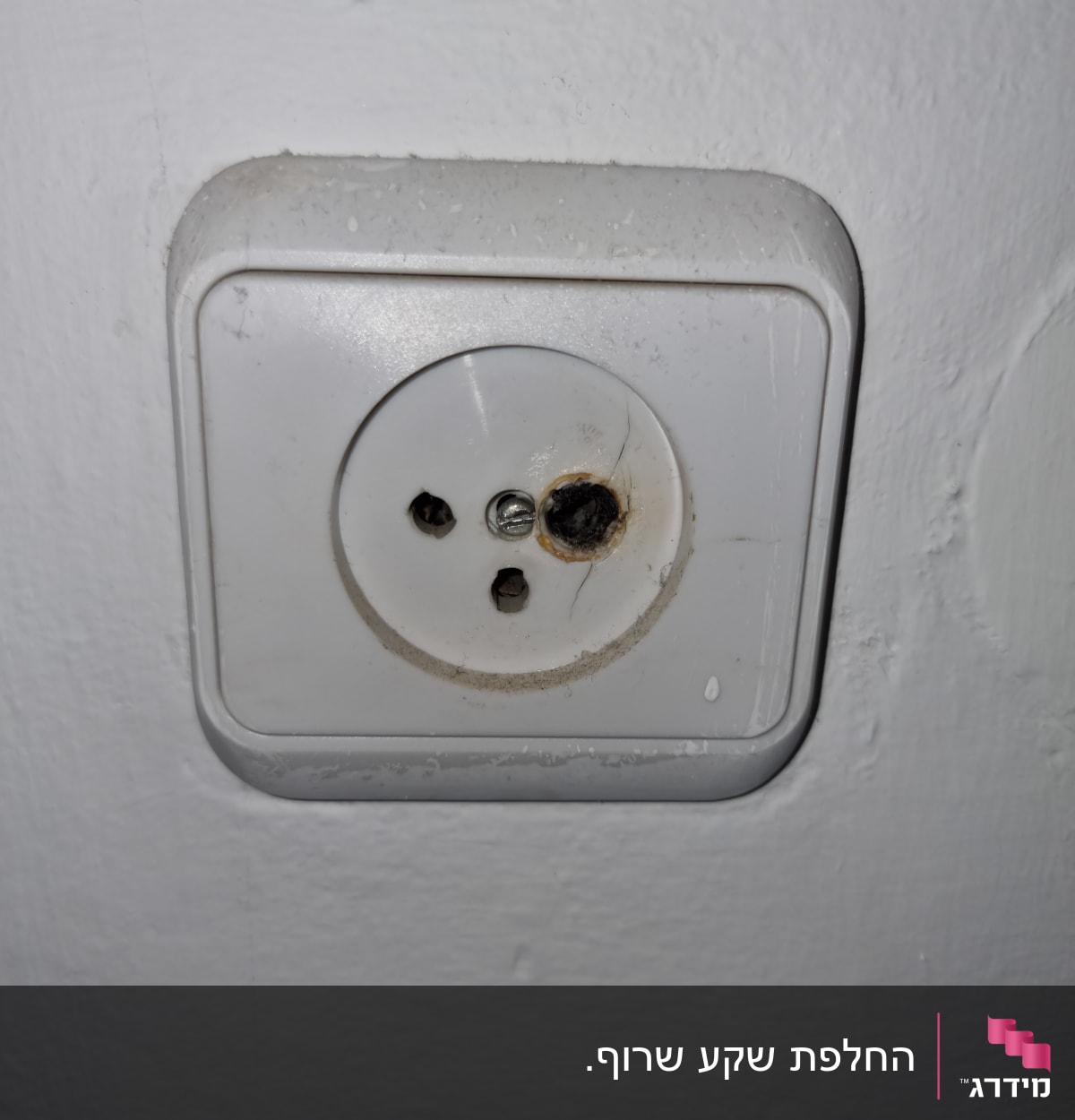 שקע חשמלי עם סימני שריפה וחלודה